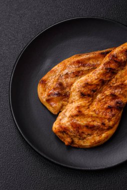 Lezzetli taze ızgara tavuk filetosu, esrarlı baharatlar ve çimento kaplı otlar. Ateşte pişirilmiş bir tabak.