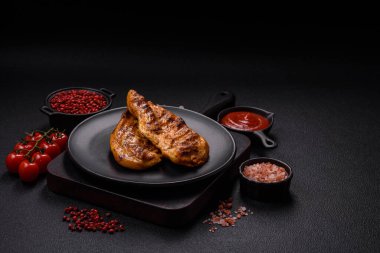 Lezzetli taze ızgara tavuk filetosu, esrarlı baharatlar ve çimento kaplı otlar. Ateşte pişirilmiş bir tabak.