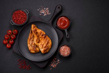 Lezzetli taze ızgara tavuk filetosu, esrarlı baharatlar ve çimento kaplı otlar. Ateşte pişirilmiş bir tabak.