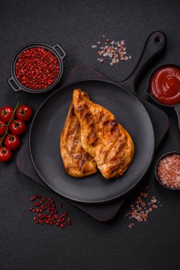 Lezzetli taze ızgara tavuk filetosu, esrarlı baharatlar ve çimento kaplı otlar. Ateşte pişirilmiş bir tabak.