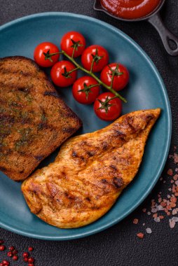 Lezzetli taze ızgara tavuk filetosu, esrarlı baharatlar ve çimento kaplı otlar. Ateşte pişirilmiş bir tabak.