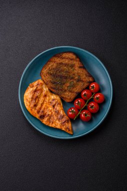 Lezzetli taze ızgara tavuk filetosu, esrarlı baharatlar ve çimento kaplı otlar. Ateşte pişirilmiş bir tabak.