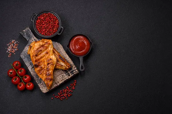 Lezzetli taze ızgara tavuk filetosu, esrarlı baharatlar ve çimento kaplı otlar. Ateşte pişirilmiş bir tabak.