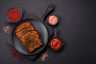 Lezzetli çıtır kıtır ekmek ya da esmer ekmekten yapılmış sarımsak soslu bruschetta ve koyu beton arka planda otlar.