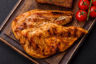 Lezzetli taze ızgara tavuk filetosu, esrarlı baharatlar ve çimento kaplı otlar. Ateşte pişirilmiş bir tabak.