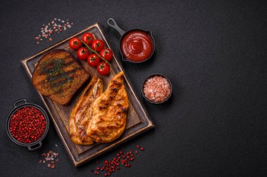 Lezzetli taze ızgara tavuk filetosu, esrarlı baharatlar ve çimento kaplı otlar. Ateşte pişirilmiş bir tabak.