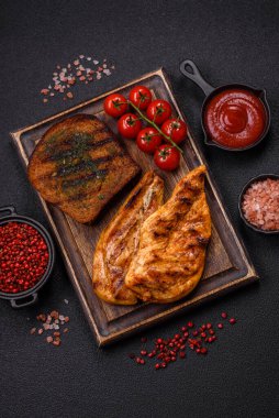 Lezzetli taze ızgara tavuk filetosu, esrarlı baharatlar ve çimento kaplı otlar. Ateşte pişirilmiş bir tabak.