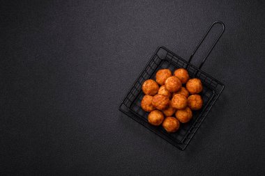 Koyu beton arka planda mozarella peyniri, tuz ve baharatla ekilmiş lezzetli gevrek toplar.