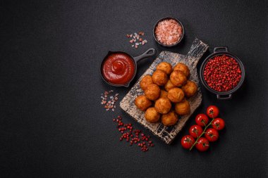 Koyu beton arka planda mozarella peyniri, tuz ve baharatla ekilmiş lezzetli gevrek toplar.