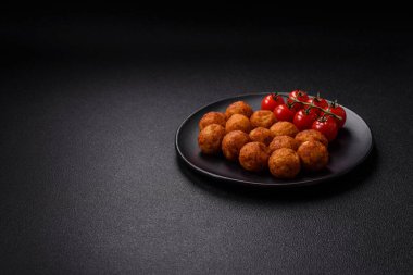 Koyu beton arka planda mozarella peyniri, tuz ve baharatla ekilmiş lezzetli gevrek toplar.
