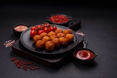 Koyu beton arka planda mozarella peyniri, tuz ve baharatla ekilmiş lezzetli gevrek toplar.