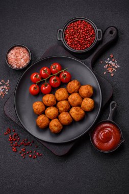 Koyu beton arka planda mozarella peyniri, tuz ve baharatla ekilmiş lezzetli gevrek toplar.