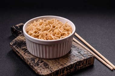 Koyu beton zemin üzerinde tuz ve baharatlı Asya usulü pirinç eriştesi.