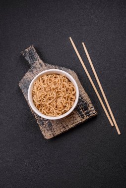 Koyu beton zemin üzerinde tuz ve baharatlı Asya usulü pirinç eriştesi.