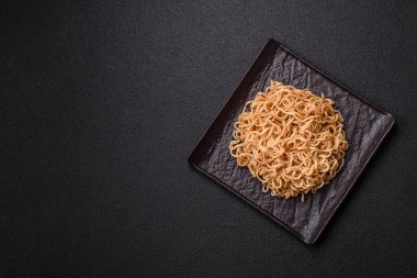 Koyu beton zemin üzerinde tuz ve baharatlı Asya usulü pirinç eriştesi.