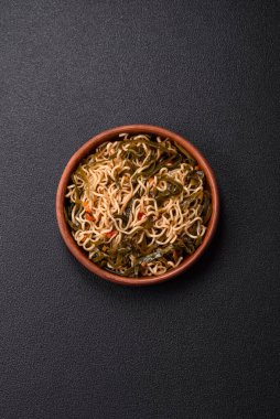 Koyu beton zemin üzerinde tuz ve baharatlı Asya usulü pirinç eriştesi.