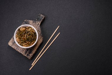 Koyu beton zemin üzerinde tuz ve baharatlı Asya usulü pirinç eriştesi.