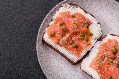 Tost, somon, krem peynir, kabak tohumu ve susam tohumlu sandviç veya bruschetta.