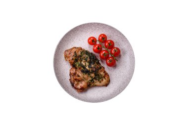 Koyu beton bir arka planda tuzlu, baharatlı ve otlu ızgara kemiksiz tavuk budu.