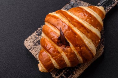 Lezzetli çıtır çıtır tatlı kruvasan kornet. Koyu beton arka planda çikolata var.