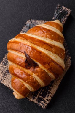 Lezzetli çıtır çıtır tatlı kruvasan kornet. Koyu beton arka planda çikolata var.