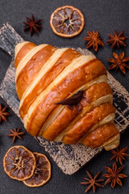 Lezzetli çıtır çıtır tatlı kruvasan kornet. Koyu beton arka planda çikolata var.