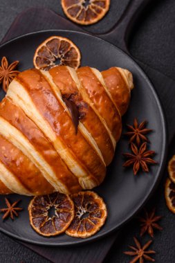 Lezzetli çıtır çıtır tatlı kruvasan kornet. Koyu beton arka planda çikolata var.