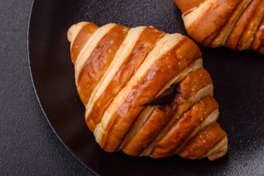 Lezzetli çıtır çıtır tatlı kruvasan kornet. Koyu beton arka planda çikolata var.
