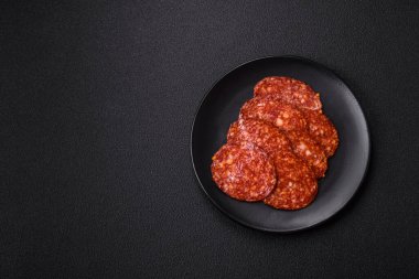 Lezzetli tütsülenmiş sucuklu sosis. Tuz, baharat ve otlarla dilimlenmiş. Koyu beton arka planda.