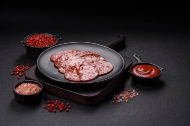 Lezzetli tütsülenmiş sucuklu sosis. Tuz, baharat ve otlarla dilimlenmiş. Koyu beton arka planda.