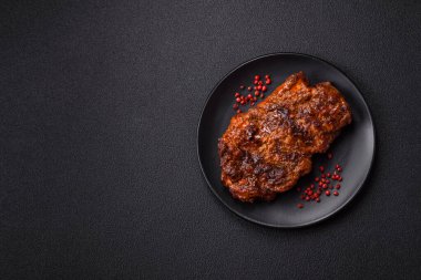 Karanlık bir arka planda taze sulu lezzetli biftek. Baharatlı ve otlu et yemeği.
