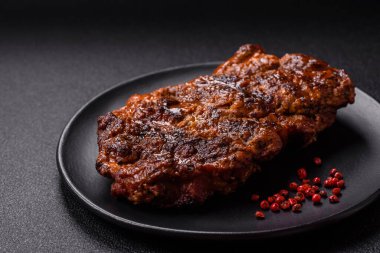 Karanlık bir arka planda taze sulu lezzetli biftek. Baharatlı ve otlu et yemeği.