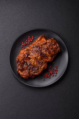 Karanlık bir arka planda taze sulu lezzetli biftek. Baharatlı ve otlu et yemeği.