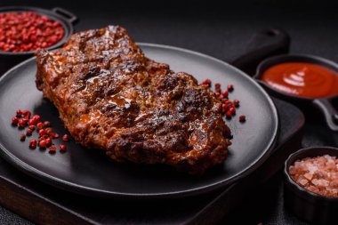 Karanlık bir arka planda taze sulu lezzetli biftek. Baharatlı ve otlu et yemeği.