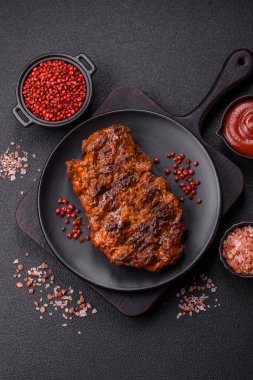 Karanlık bir arka planda taze sulu lezzetli biftek. Baharatlı ve otlu et yemeği.