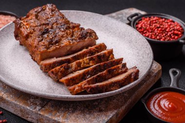 Karanlık bir arka planda taze sulu lezzetli biftek. Baharatlı ve otlu et yemeği.