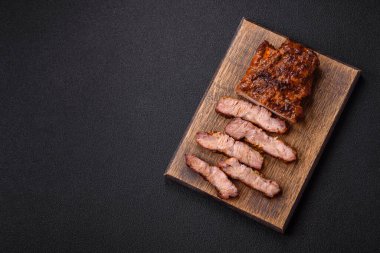 Karanlık bir arka planda taze sulu lezzetli biftek. Baharatlı ve otlu et yemeği.