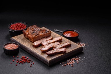 Karanlık bir arka planda taze sulu lezzetli biftek. Baharatlı ve otlu et yemeği.