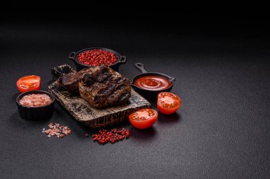 Karanlık bir arka planda taze sulu lezzetli biftek. Baharatlı ve otlu et yemeği.