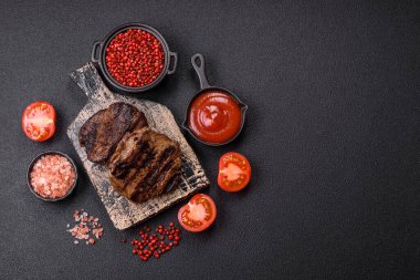 Karanlık bir arka planda taze sulu lezzetli biftek. Baharatlı ve otlu et yemeği.