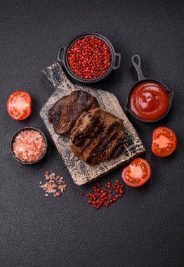 Karanlık bir arka planda taze sulu lezzetli biftek. Baharatlı ve otlu et yemeği.
