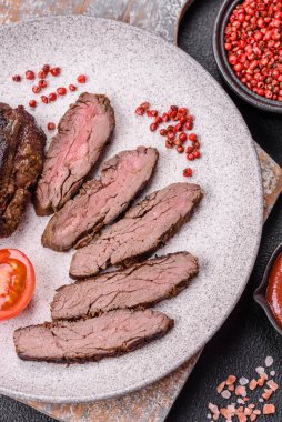 Karanlık bir arka planda taze sulu lezzetli biftek. Baharatlı ve otlu et yemeği.