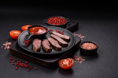 Karanlık bir arka planda taze sulu lezzetli biftek. Baharatlı ve otlu et yemeği.