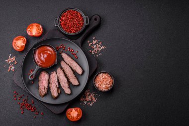 Karanlık bir arka planda taze sulu lezzetli biftek. Baharatlı ve otlu et yemeği.