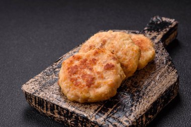 Lezzetli taze kıymalı balık pirzolası. Esmer arka planda baharatlar ve otlarla birlikte.