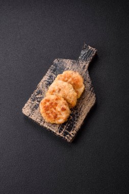 Lezzetli taze kıymalı balık pirzolası. Esmer arka planda baharatlar ve otlarla birlikte.