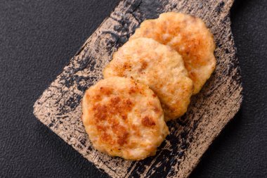 Lezzetli taze kıymalı balık pirzolası. Esmer arka planda baharatlar ve otlarla birlikte.