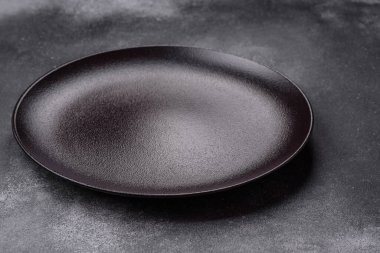 Koyu dokulu arka planda boş seramik tabak. Aile yemeği için mutfak gereçleri hazırlıyorum.