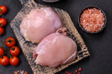 Koyu beton bir masada baharat ve otlarla taze tavuk filetosu. Et yemekleri için hazırlık.