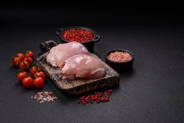 Koyu beton bir masada baharat ve otlarla taze tavuk filetosu. Et yemekleri için hazırlık.